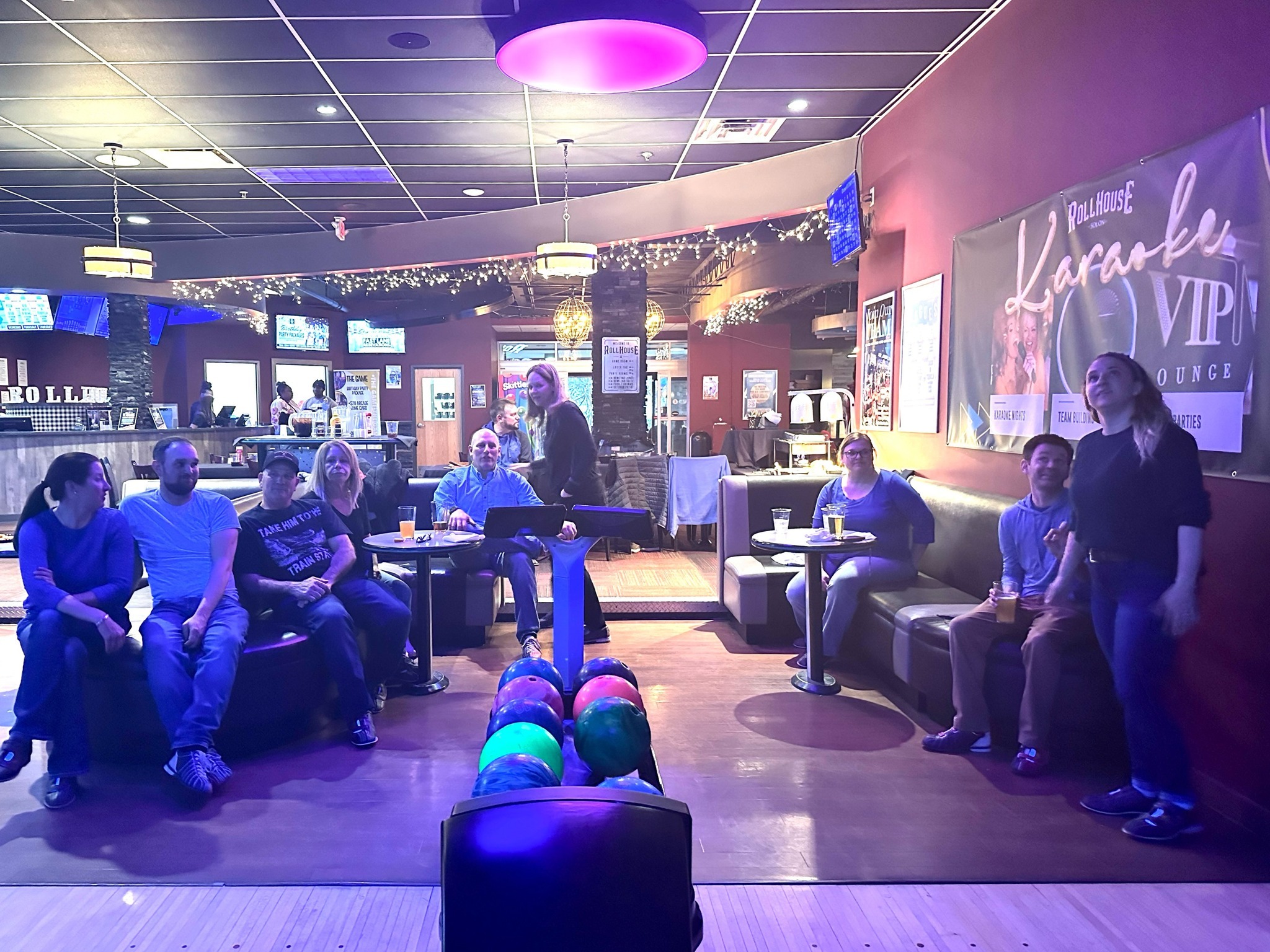 Ralston employees enjoying a casual night of bowling, sitting together near the lanes.