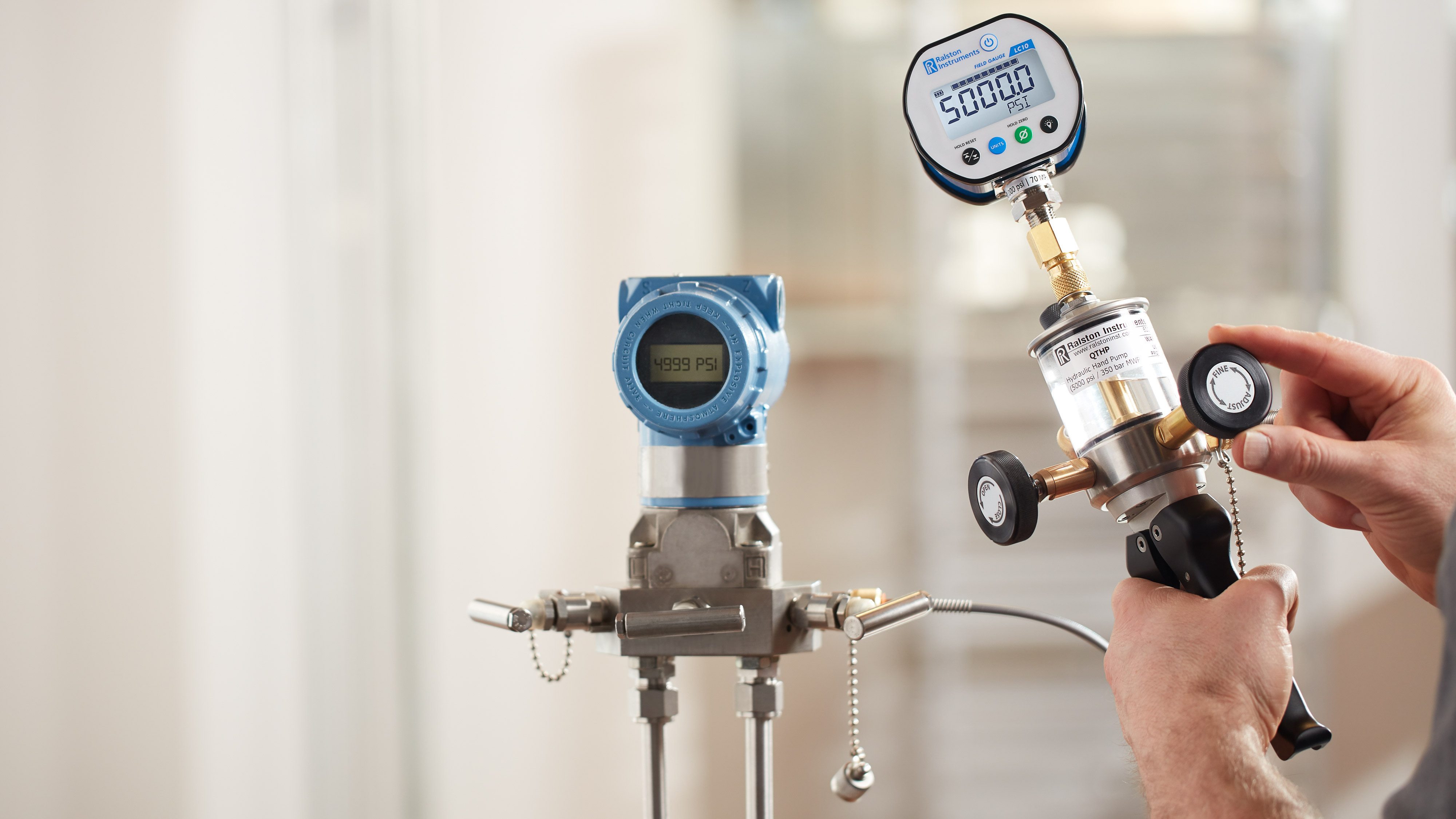 Technician using a Ralston hydraulic hand pump to calibrate a pressure transmitter, showing temperature pressure changes.