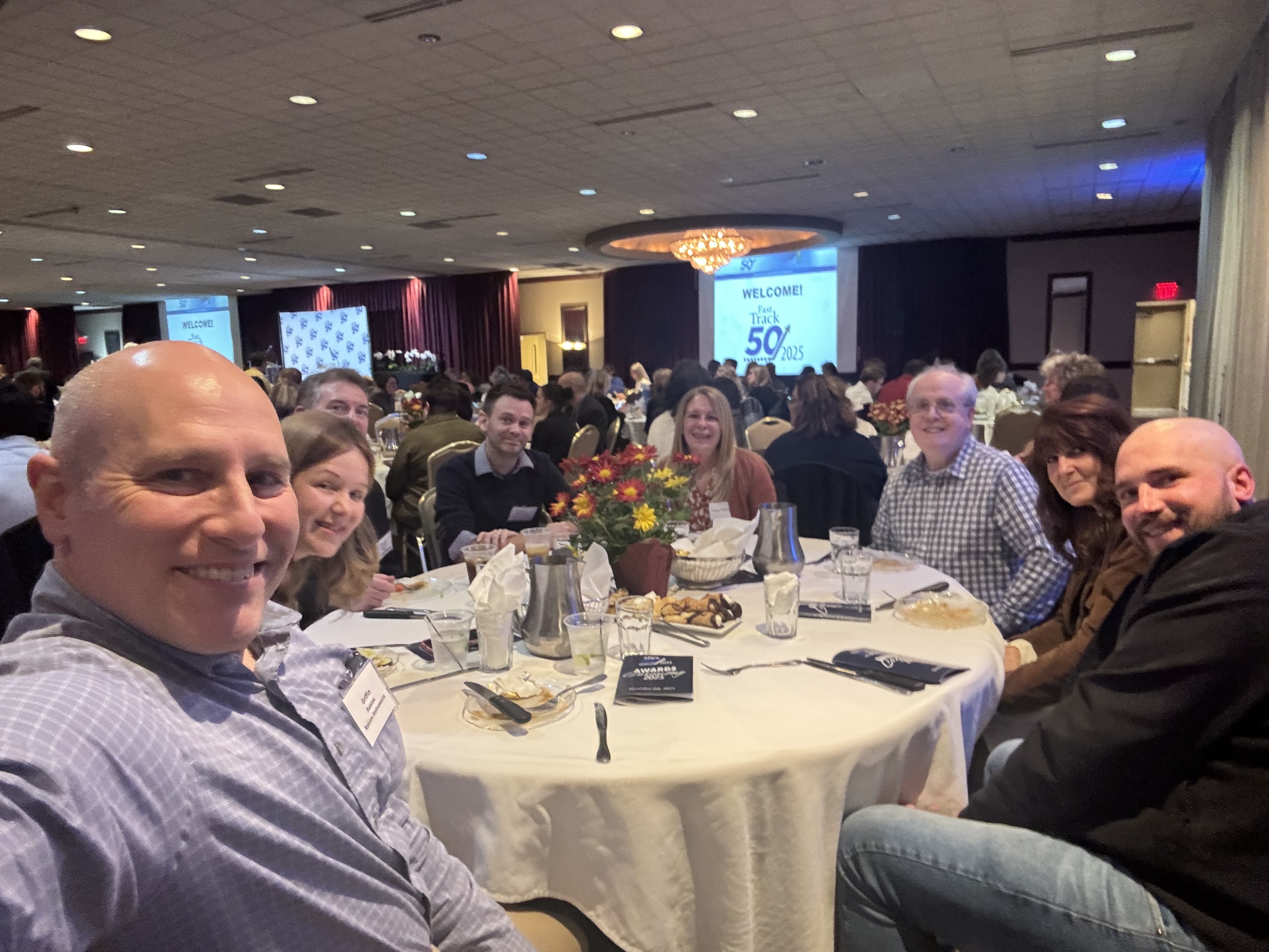 Ralston Instruments employees seated together at a round table during the Fast Track 50 awards dinner in Mentor, Ohio.