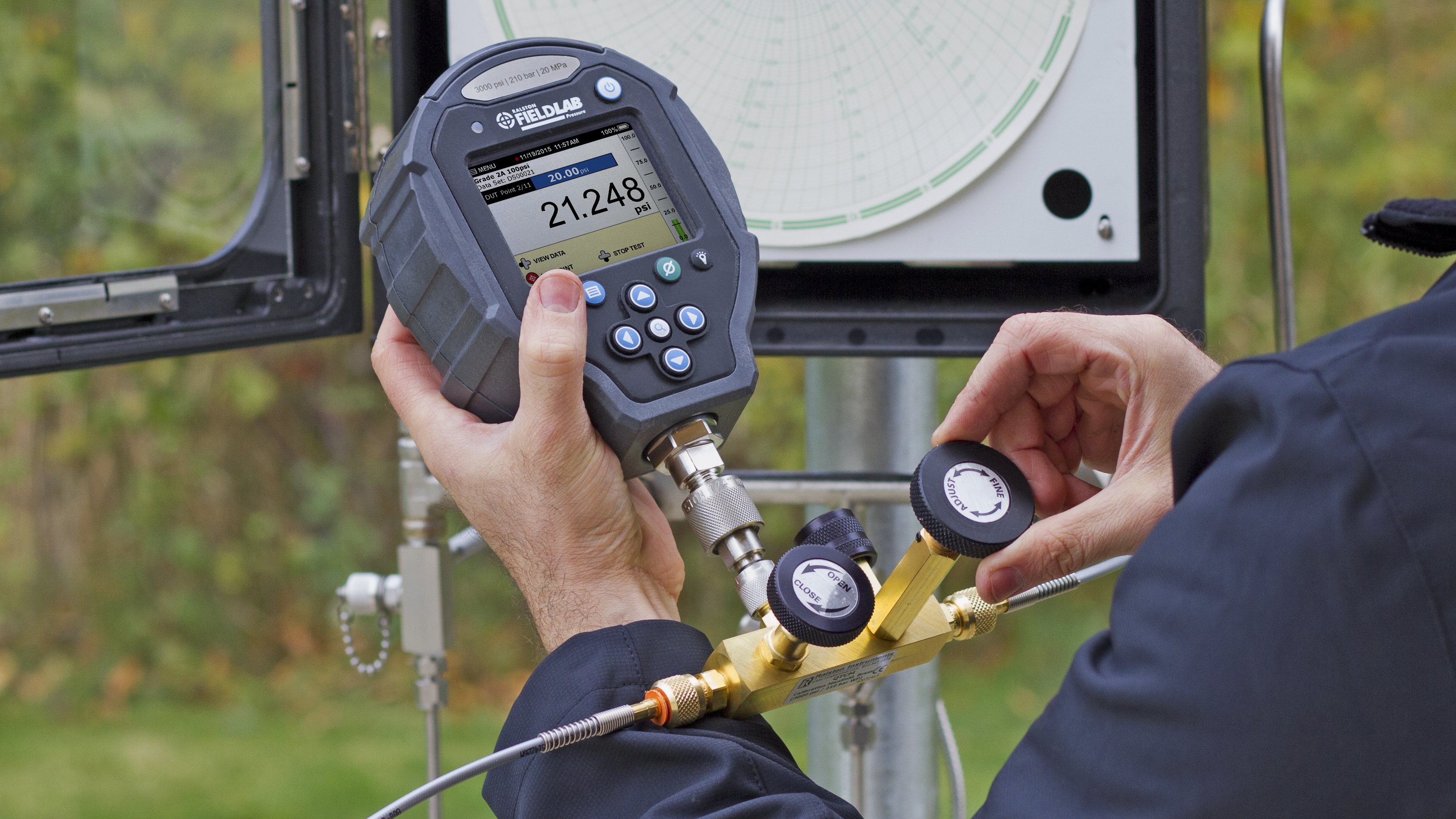 Technician using a Ralston FieldLab pressure calibrator during chart recorder calibration.