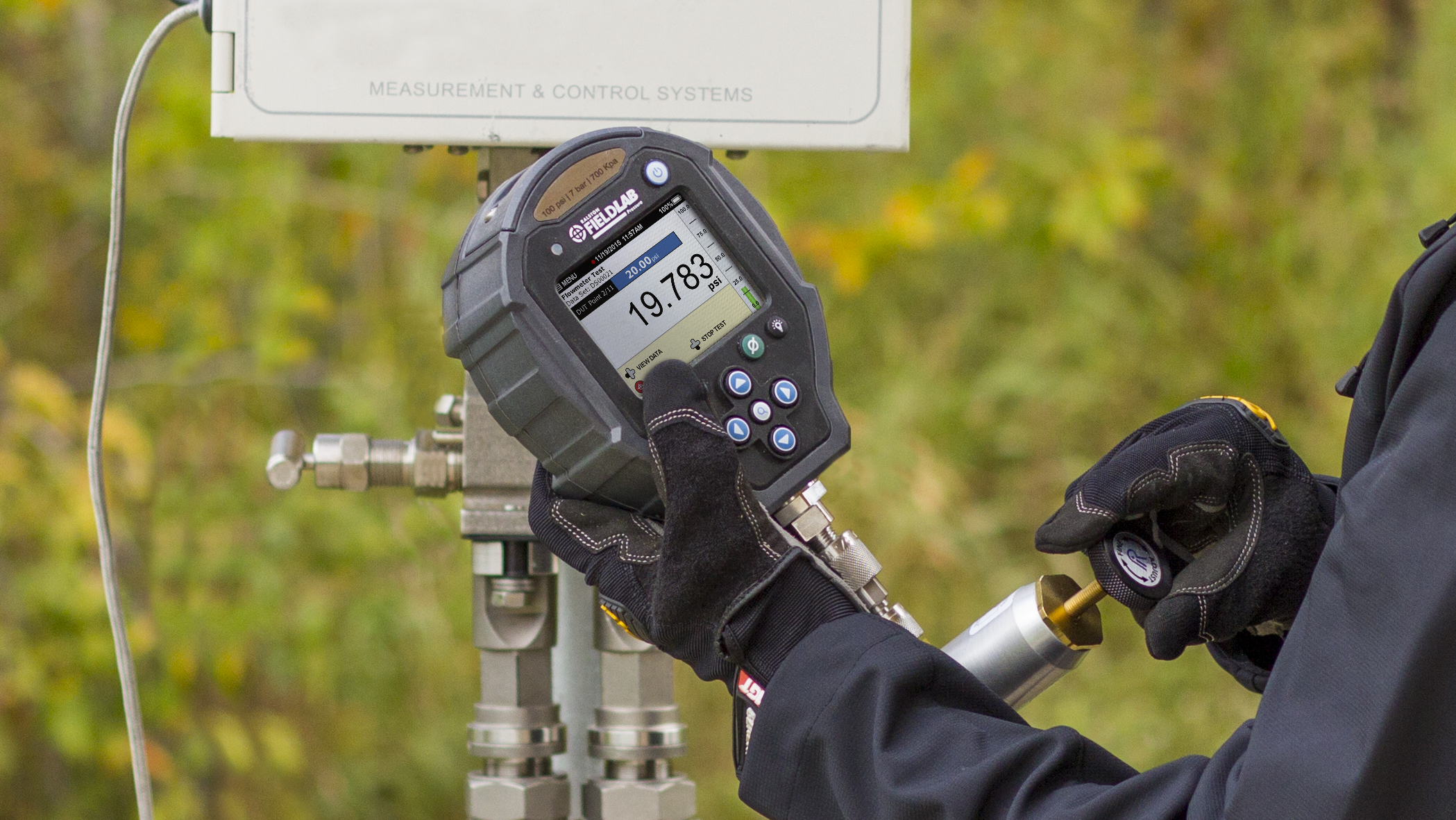 Technician using a Ralston FieldLab Pressure Calibrator to measure and verify pressure during field calibration.
